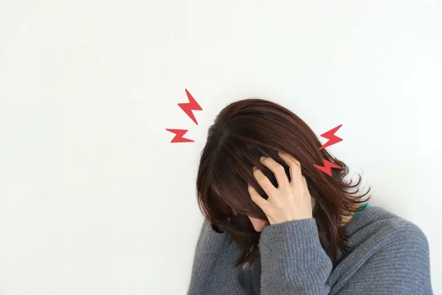 頭痛やめまいを感じる女性