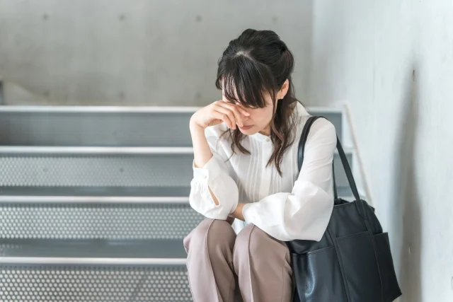 疲れて階段に座り込む女性