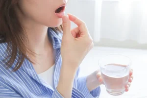 薬を飲む女性の手元
