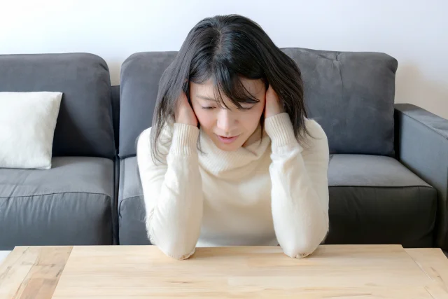 ソファで悩む女性のストレスイメージ