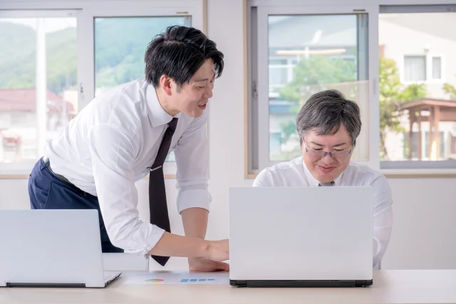 職場で相談するビジネスパーソン