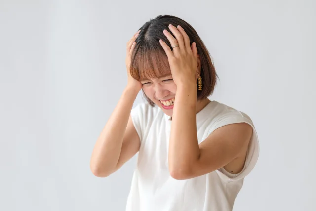 頭を抱えて不安な様子の女性