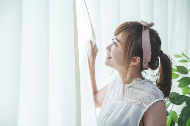 朝日を浴びて前向きな表情の女性