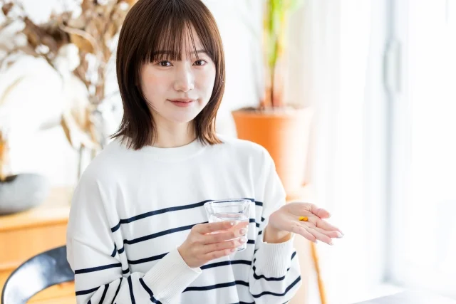 薬を飲む女性